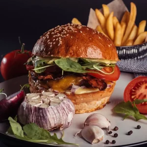 Populárny Aioli burger v Košiciach, bohatý na chutí s čedarom, slaninou a rukolou v žemli.